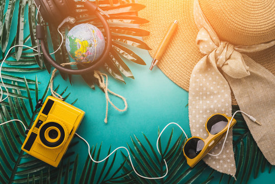 summer vacation and travel concept with travel stuff camera notebook glasses and woman hat flatlay image on color background with free copy space