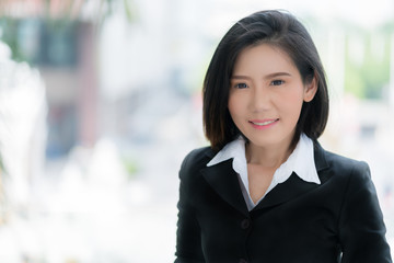 beautiful smart asian businesswoman short hair with black suit and blur background portrait photo
