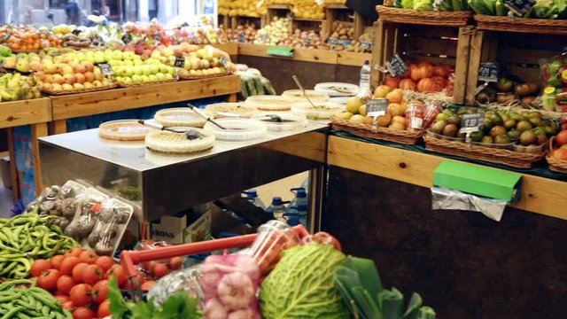 Variety of fresh vegetables and fruits in shopping cart in greengrocery