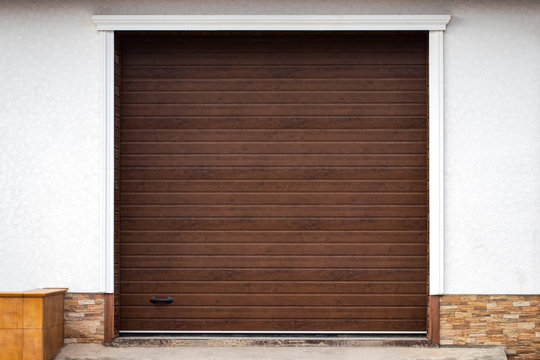 Wooden wall of modern rural garage with the automatic lifted gate