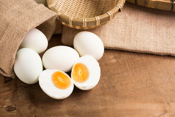 salted duck egg with utensil on old wooden table in kitchen. food preservation concept.