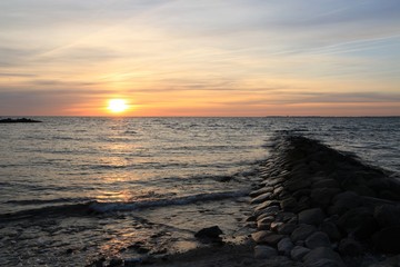 romantischer Sonnenaufgang an einer Buhne an der Ostsee