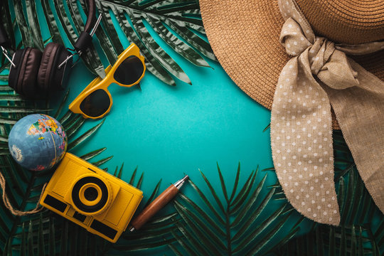 summer concept with travel stuff camera notebook glasses and woman hat flatlay image on color background with free copy space