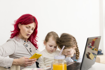 Obraz na płótnie Canvas Work-From-Home Mom Texting with Kids on Her Lap