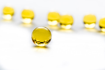 Fish fat round pills on white background, medicine capsule contains omega 3 vitamin