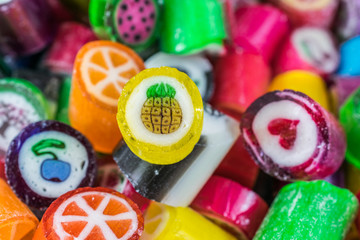 Colorful candy sweets close up, selective focus. Different tastes and drawings of fruits on candies, pineapple taste in front, made in prague
