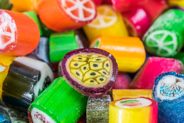 Colorful candy sweets close up, selective focus. Different tastes and drawings of fruits on candies, passionfruit taste in front, made in prague