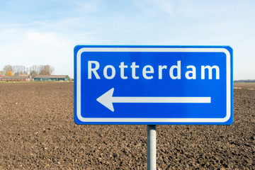 Large blue sign with a white arrow in the direction of Rotterdam