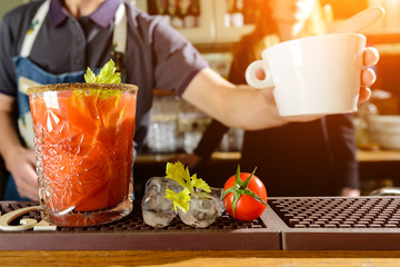 Unidentified bartender preparing cocktail Bloody Mary at the bar counter. Selective focus