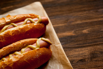 Barbecue Grilled Hot Dogs with yellow American mustard, On a dark wooden background