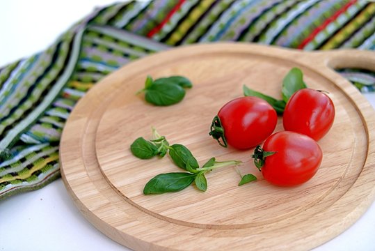 Ripe tomatoes and basil on a wooden board