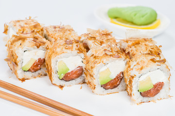 Traditional Japanese cuisine. Tasty sushi rolls with rice, cream cheese, salmon and tuna on light background