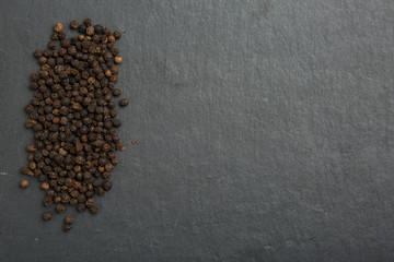 Black pepper on dark stone background