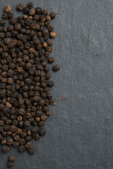 Black pepper on dark stone background
