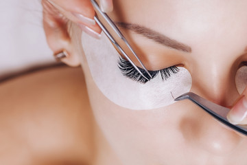 Eyelash Extension Procedure. Woman Eye with Long Eyelashes. Close up, selective focus. - 199687713