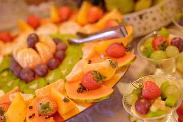 Colorful fruit platter with a large variety of exotic and season fruit, prepared for a food bar, reception or any type of celebration, in tune with any vegan choices, and today’s healthy living mantra