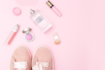 Obraz na płótnie Canvas Pink sneakers and pink cosmetics on a pink background. Copy space