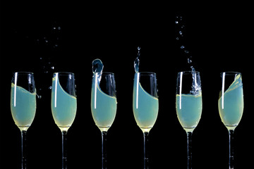 Six glasses of cocktail on a black background.	