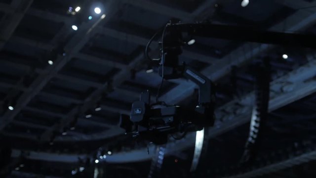 TV camera on a crane on football mach or concert close up