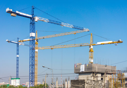 Group of high tower cranes in workplace. Building construction industrial in Thailand, Southeast Asia.