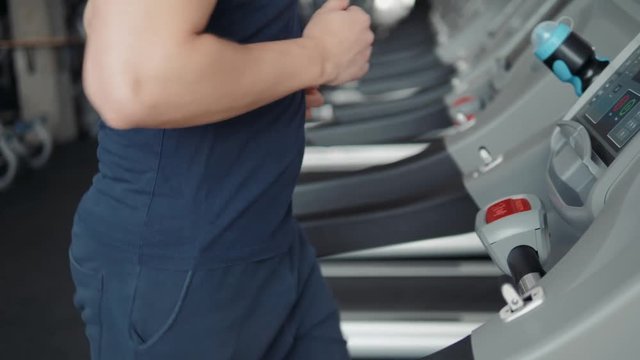 Close up of man finger pushing stop button on treadmill. Safety in gym, end of training