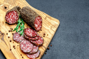 Dried organic salami sausage on wooden cutting board