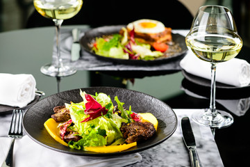 Tasty dish with juicy beef steak and fresh lettuce leaves at a restaurant