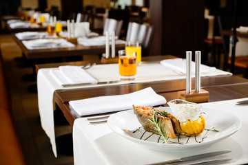 Appetizing fish served with lemon and sauce in a plate at a restaurant
