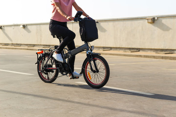 Fototapeta premium A young woman riding an electric bicycle