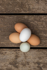 a top down view of a pile of eggs sitting on a barn wood surface.