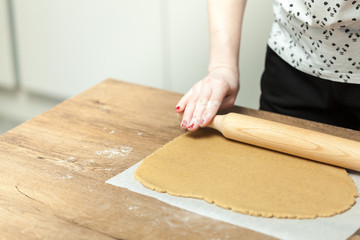 close up of female hands making cookies from fresh dough at home