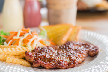 Pork Steak barbecue, salad, bread and potato chips. Blurred background.
