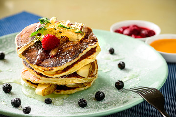 Sweet delicious pancake blinis with jam and berries in the plate. New restaurant menu for the holiday Maslenitsa