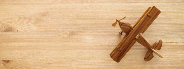 top view photo of toy airplane over wooden background.