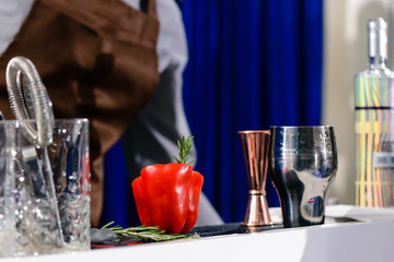 Special bell-pepper cocktail in bell-pepper with rosemary on the bar counter
