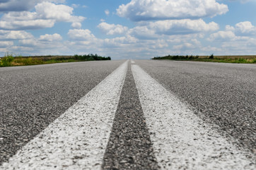 asphalt road closeup with two white lines in center