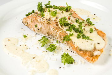 Fried Salmon with cheese sauce, parsley and pepper.