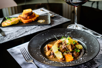 Juicy duck fillet with potatoes and mushrooms in a plate in restaurant, selective focus