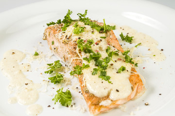 Fried Salmon with cheese sauce, parsley and pepper.