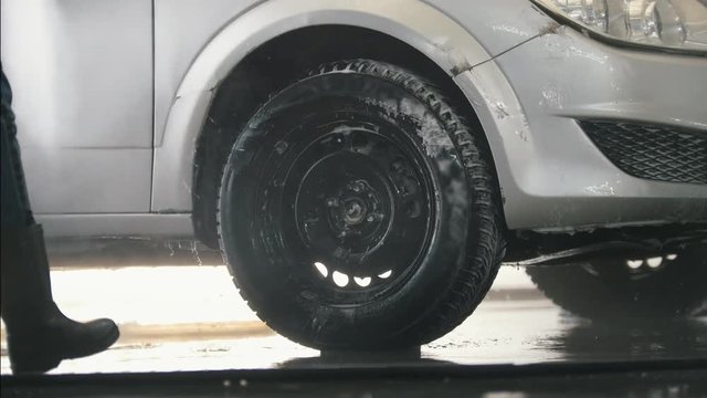 Worker washing the car salon with water hose