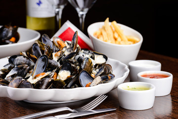Delicious Shellfish Traditional Mussels with sour cream sauce on the table at a restaurant