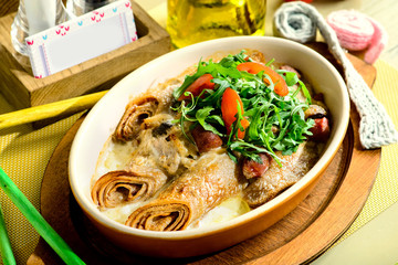 Delicious pancake blini with sausages, tomatoes and basil leaves. New restaurant menu for the holiday Maslenitsa