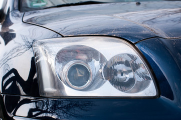 Head light on modern dirty japanese car close up shot. 
