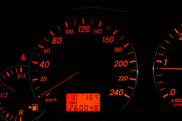 Orange colored modern japanese car dashboard close up on black background.