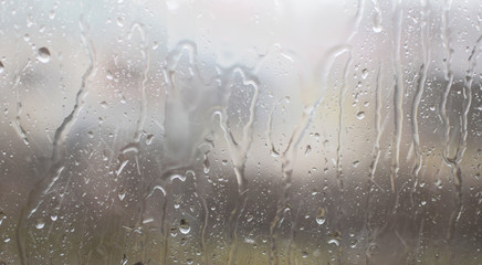 Closeup of water raindrops on window glass surface at home as abstract background.