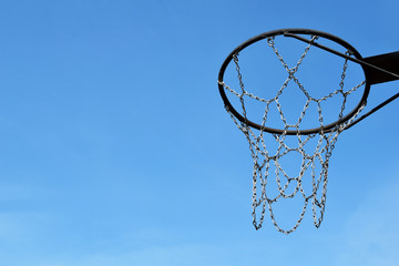 Basketball metal hoop outdoors on bright blue sky background with copy space for text. Sport and active lifestyle concept.