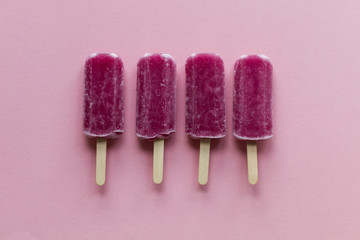 Raspberry flavour summertime ice lollies on a pink background