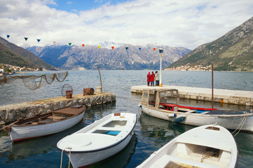 Fototapeta na wymiar Cold day. Montenegro, view of Bay of Kotor near small harbor with fishing boats in Stoliv village