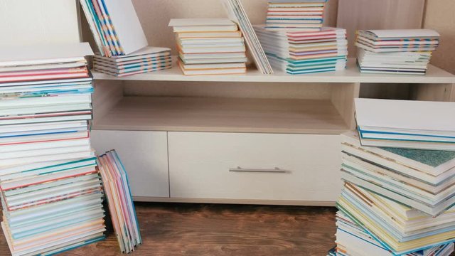 Pile of books on the floor and on the closet.
