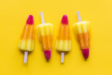 Rocket shaped summer ice lolly on a bright yellow background